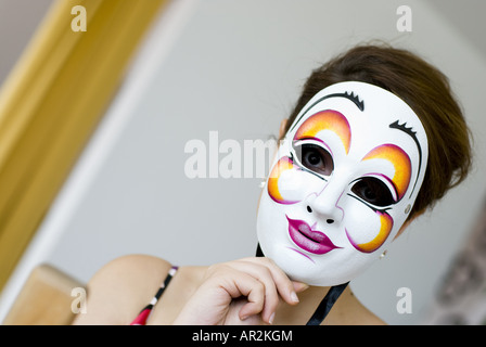 junge Frau hinter der Maske Stockfoto