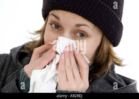 Frau bläst mit Kappe ihre Nase Stockfoto