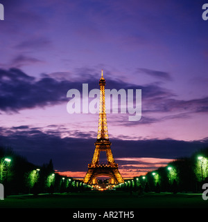 Paris, Frankreich, den Eiffelturm, die mit Flutlicht bei Sonnenuntergang, als aus dem Champ-de-Mars gesehen. Stockfoto