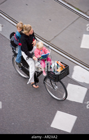 HOLLAND-AMSTERDAM-MUTTER MIT ZWEI KINDERN AUF EINEM FAHRRAD MIT SHOPPING KORB Stockfoto