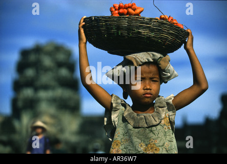 Mädchen trägt einen Korb mit Früchten auf dem Kopf, Angkor Wat, Siem Raep, Kambodscha, Asien Stockfoto