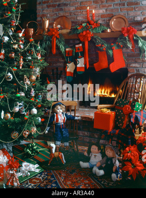 Weihnachten-Stillleben mit lodernden Kamin und fröhlich geschmückter Weihnachtsbaum mit Geschenken Stockfoto