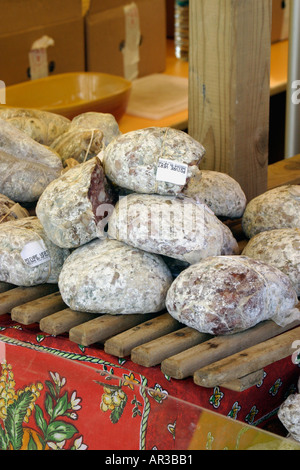 Auswahl an Fleisch hängen und Würstchen am Marktstand auf Lattenrost Holztabletts Stockfoto