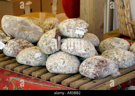 Auswahl an Fleisch hängen und Würstchen am Marktstand auf Lattenrost Holztablett Stockfoto