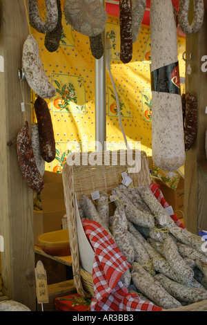 Auswahl an Fleisch hängen und Würstchen am Marktstand in Weidenkörbe Stockfoto