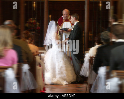 Braut und Bräutigam den Austausch von Eheversprechen vor Pfarrer und Gemeinde in der Kirche. Stockfoto