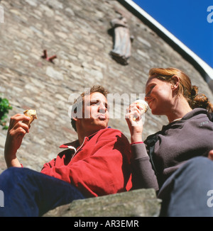 Ein junges Paar mit Eiscreme-Kegel im Gespräch Hay on Wye, Wales, UK KATHY DEWITT Stockfoto