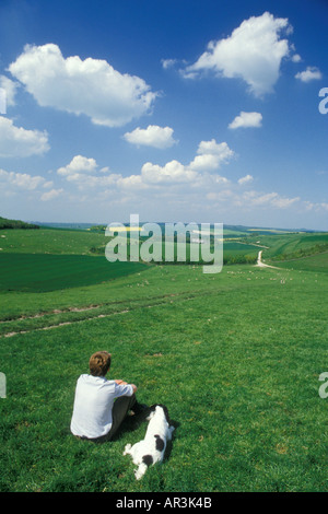 Junger Mann mit Hund einen Blick auf die Wiltshire Downs in der Nähe von Marlborough Stockfoto