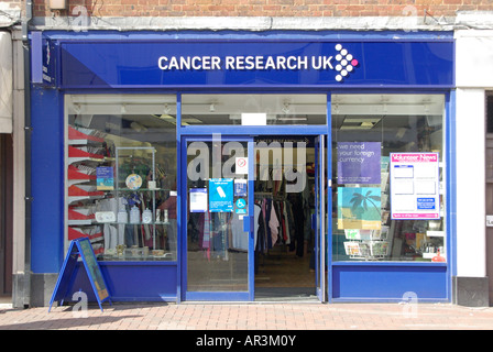 Cancer Research Wohltätigkeitsgeschäft mit Fenstern und offener Tür in den Einkaufszentren der Innenstadt, High Street, Essex, England, Großbritannien Stockfoto