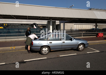 BAA Flughafen London Heathrow T4 Ankunft am Drop-off Point - 2 Personen entladen Auto MRed Stockfoto