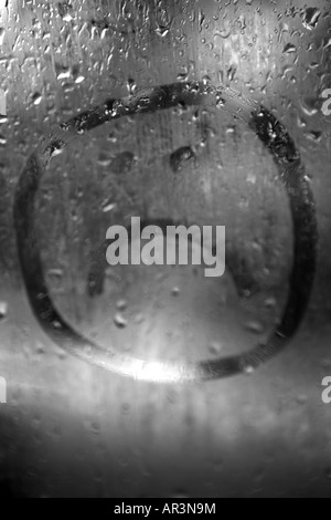 Trauriges Gesicht auf die Kondensation in einem verregneten Fenster gezeichnet Stockfoto
