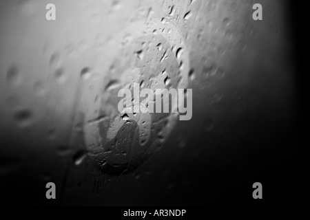 Trauriges Gesicht auf die Kondensation in einem verregneten Fenster gezeichnet Stockfoto