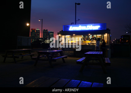 London-Diner dienen außerhalb der Hütte an der North Greenwich Station, London mit Canary Wharf im Hintergrund Stockfoto