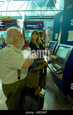 BAA Passagier mit Selbsttest in London Heathrow T4 - bärtiger Mann und Frau hinter MRed Stockfoto