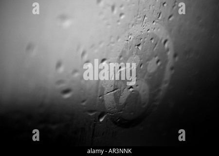 Trauriges Gesicht auf die Kondensation in einem verregneten Fenster gezeichnet Stockfoto