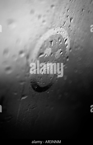 Trauriges Gesicht auf die Kondensation in einem verregneten Fenster gezeichnet Stockfoto