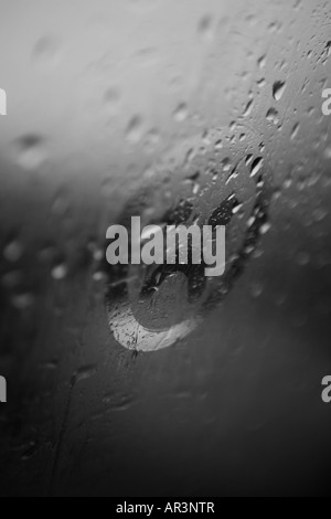 Trauriges Gesicht auf die Kondensation in einem verregneten Fenster gezeichnet Stockfoto