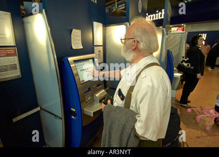 Männlichen Passagier (60er Jahre) mit self check-in am London Heathrow Airport Terminal 4 T4 - bärtigen Mann MRed Stockfoto
