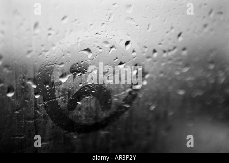 Trauriges Gesicht auf die Kondensation in einem verregneten Fenster gezeichnet Stockfoto