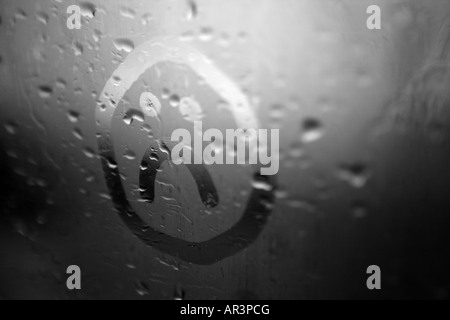 Trauriges Gesicht auf die Kondensation in einem verregneten Fenster gezeichnet Stockfoto