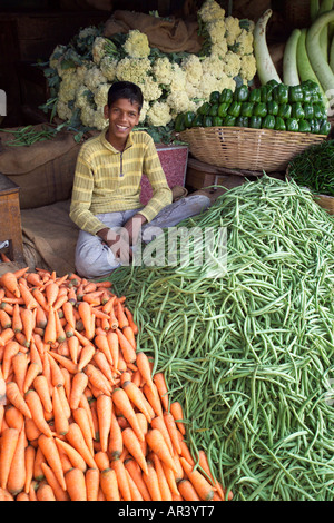 Lächelnde junge Verkauf von Gemüse, Möhren und grüne Bohnen, Devaraja Obst und Gemüsemarkt, Mysore, Indien Stockfoto