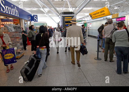 Passagiere im Flughafen Stansted zu Fuß in Richtung Sicherheit Stockfoto