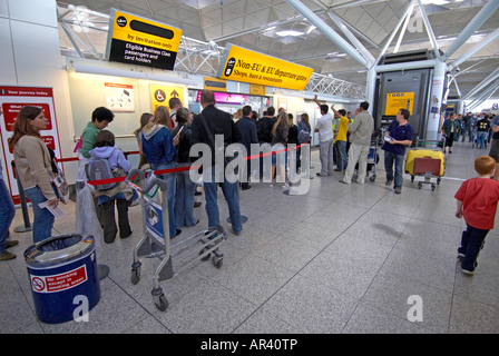 Passagiere im Flughafen Stansted zu Fuß in Richtung Sicherheit Stockfoto