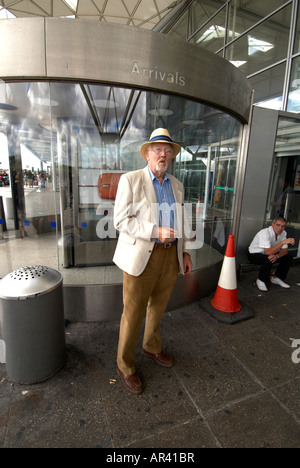 Passagier Rauchen außerhalb Stansted Airport - nur der Mann stand UP ist Modell veröffentlicht. Stockfoto