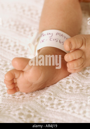 Nahaufnahme von neugeborenen Mädchen Füße und id Armband, kleine niedliche Zehen, Großbritannien, Großbritannien Stockfoto