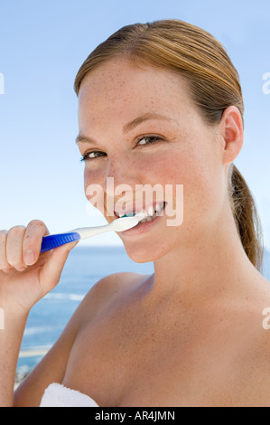 Junge Frau, die sich die Zähne putzen Stockfoto