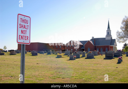 "Du sollst nicht betreten"-Schild an der Kirche und dem Friedhofstor, symbolisiert religiöse Autorität und eingeschränkten Zugang, USA. Stockfoto