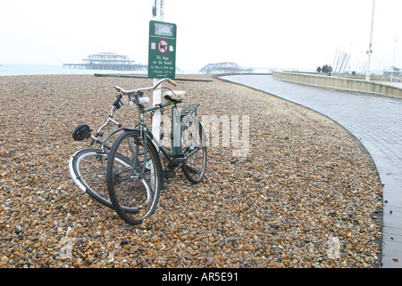 Fahrräder, angekettet an einen Laternenpfahl auf Brighton beach Stockfoto