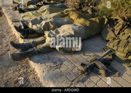 Israelische Soldaten schlafen auf einem Bürgersteig in der Stadt Metula nach der Rückkehr von einer Nacht-Mission im südlichen Libanon in Israel - Hisbollah Krieg Stockfoto