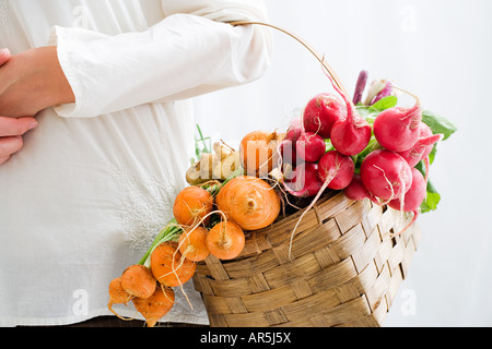 Frau hält Korb mit rote Beete und Radieschen Stockfoto