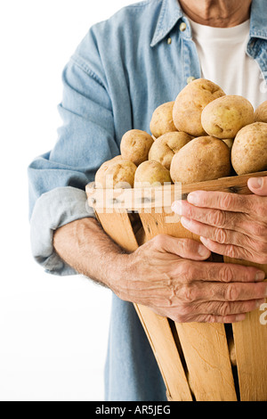 Mann-Betrieb-Korb mit Kartoffeln Stockfoto