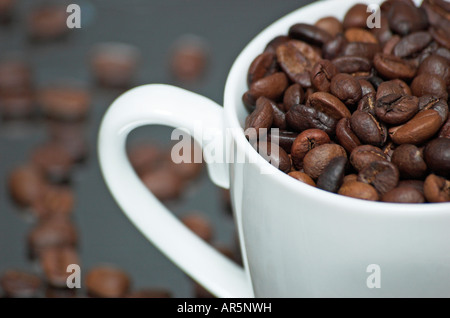 Tasse Kaffee voller Kaffeebohnen Stockfoto