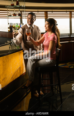 Mitte adult afroamerikanische Mann und Hispanic Frau Toasten in bar Stockfoto