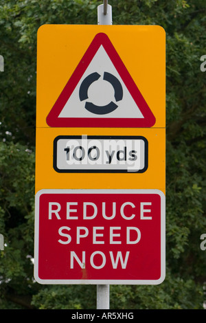 Reduzieren der Geschwindigkeit jetzt Kreisverkehr 100 Yards vor Straßenschild Stockfoto
