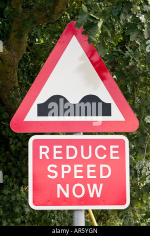 Achtung reduziert jetzt Geschwindigkeitsbegrenzungen in Straße-Verkehrszeichen Stockfoto