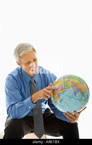 Applying kaukasischen Mann halten Globus und zeigt Stockfoto