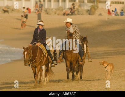 Mexiko Nayarit Dorf Sayulita auf den Pazifischen Ozean mexikanische Cowboy und touristischen Reiten am Strand Stockfoto