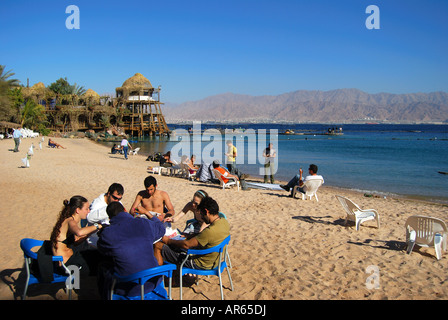 Gruppe am Tisch am Strand, Dolphin Reef, Eilat, South District, Israel Stockfoto