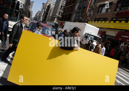 Mann trägt Gelb an Bord, Canal Street, Trebeca, Chinatown, Manhattan, New York City, New York, Vereinigte Staaten von Amerika, USA Stockfoto