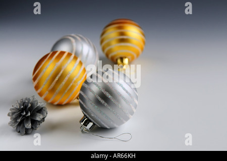 Weihnachtsarrangement mit Glas Christbaumkugel Ornamenten und Tannenzapfen Stockfoto