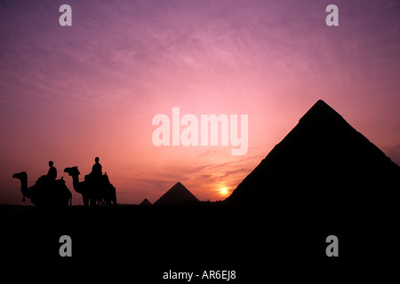 Datenanalyse-Sonnenuntergang mit Männern mit Kamelen Silhouette gegen den berühmten Pyramiden von Gizeh-Ägypten Stockfoto