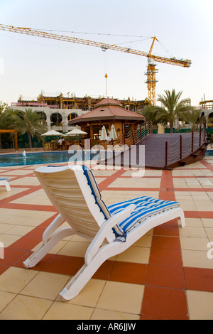Website in Ras Al Khaimah Strand Club UAE, Schwimmbad mit Baukran Stockfoto