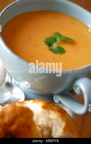 Karotten und Koriander-Suppe in blau Schüssel mit weißen Brötchen Stockfoto