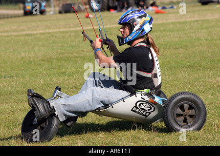 Kite Flyer auf einen Buggy auf dem Rasen in einen Sturzhelm zu beschleunigen Stockfoto