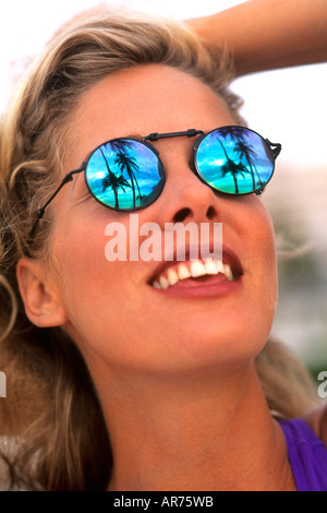 Schöne Frau mit Sonnenbrille und Reflexion von Urlaub in Palmen und Karibik sehen Stockfoto