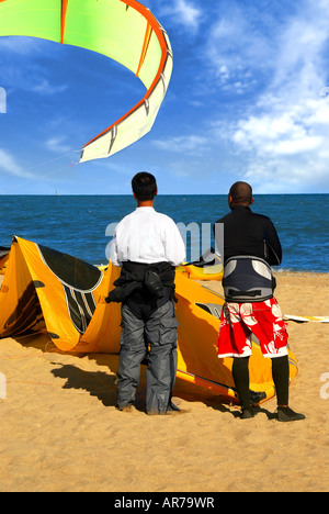 Zwei Kitesurfern stehend an einem Strand am Ozean beobachten Stockfoto